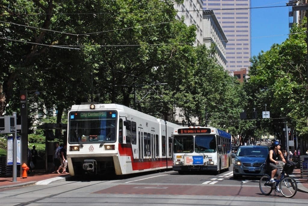 MAX train and a transport bus carrying commuters in portland transport advertising agency