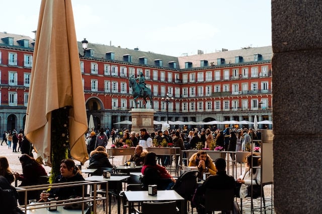 people enjoying their meal sitting on chairs , Madrid advertising agency
