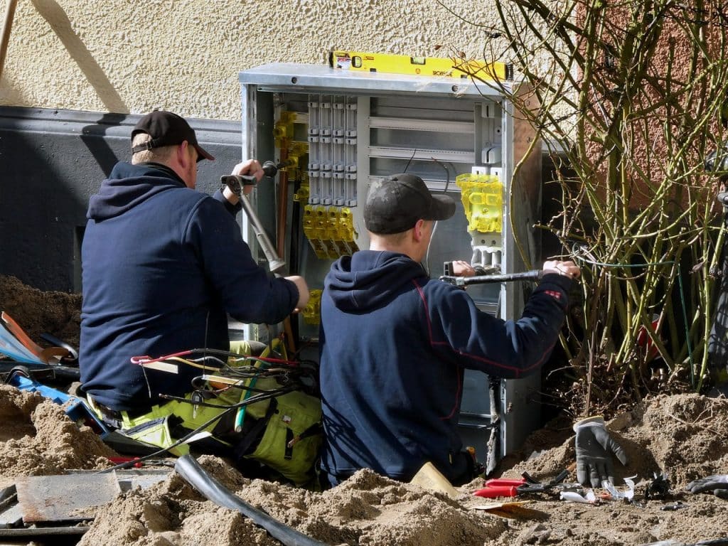 Electricians installing high-voltage cabinet, Electrician Advertising Agency.