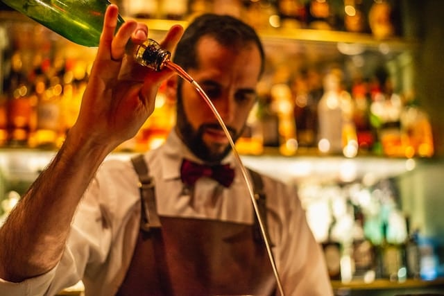 A bartender making a cocktail, Liquor Store Advertising.