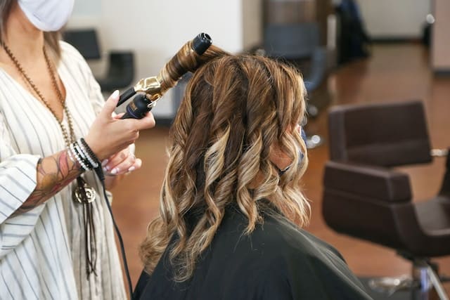 Hairdresser treating the hair of a client, Hair Salon Advertising Agency.