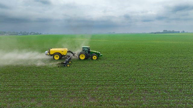 A tractor spraying in a field, Pest Control Advertising Agency.