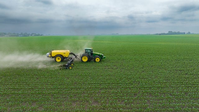 A tractor spraying in a field, Pest Control Advertising Agency.