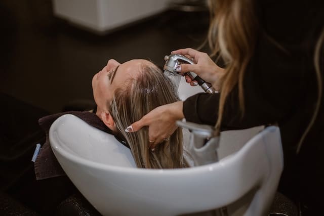 Hairdresser washing hair of a customer, Hair Salon Advertising Agency.