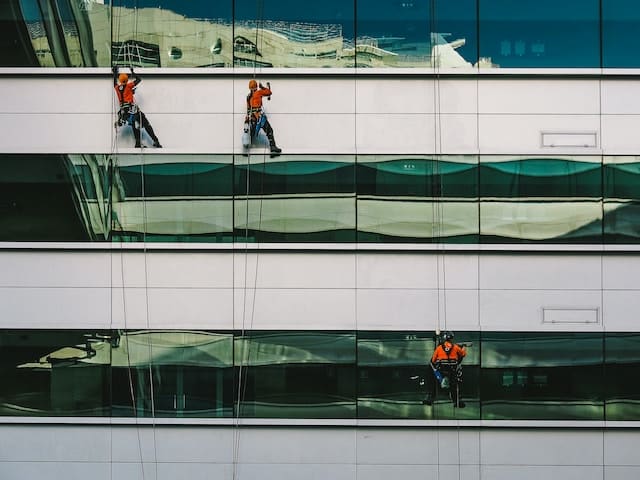 Janitors cleaning the windows of a building, Janitorial Advertising Agency.