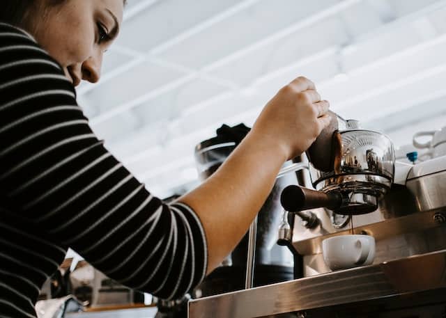 A woman making a cup of coffee, Beverage Advertising Agency.