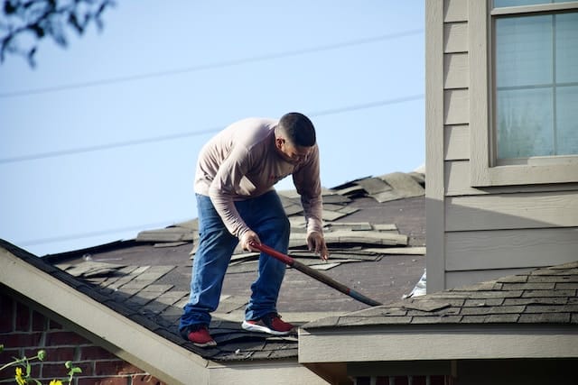 A worker on the top of the roof, Roofing Advertising Agency.